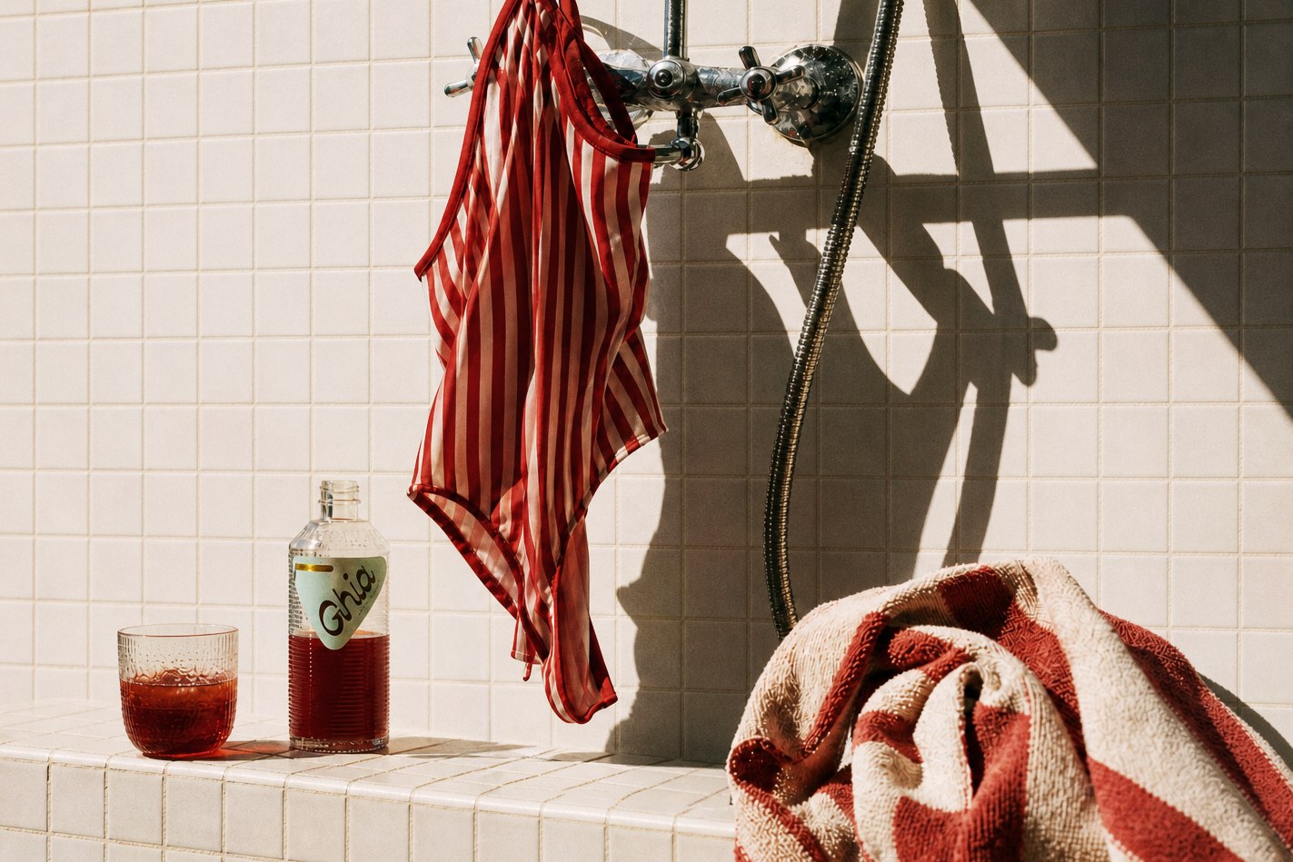 Red striped swimsuit near Ghia bottle and glass after swimming