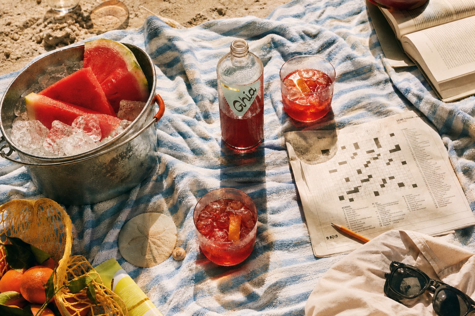 Improvised beach aperitif setup on a striped towel